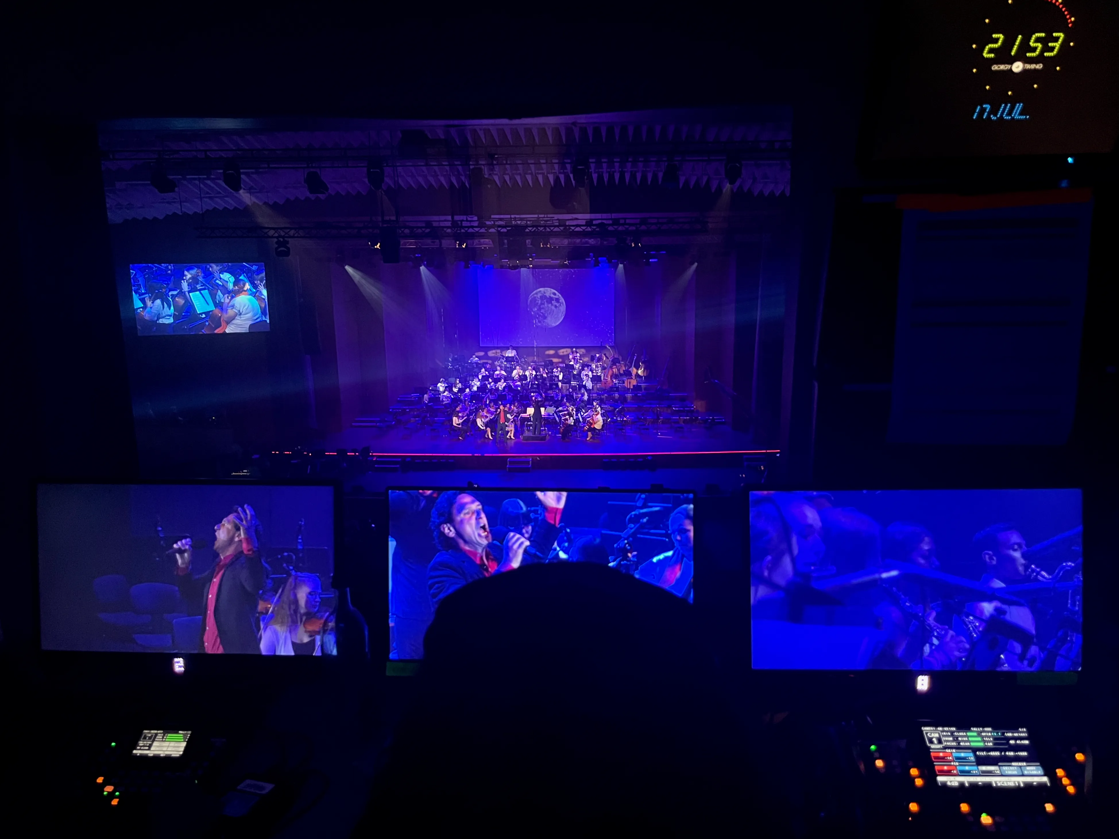 Bühne mit Orchester, Bildschirme im Vordergrund